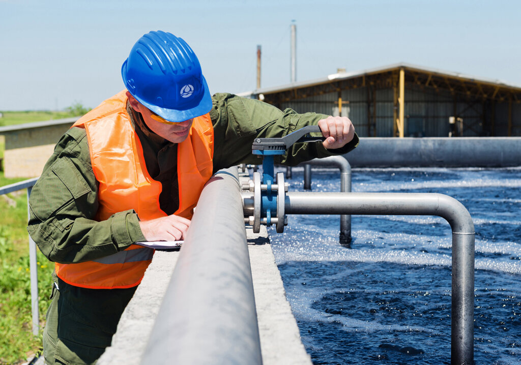 An engineer controlling the quality of water , aerated activated sludge tank at a waste water treatment plant .