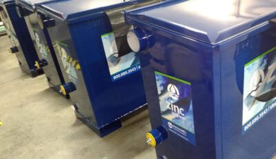 Seven blue Zinc-B-Gone filter units sit in a warehouse ready for shipment