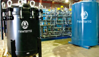 Two Newterra branded elevated tank vessels connect to a ground remediation system in an industrial processing buiding