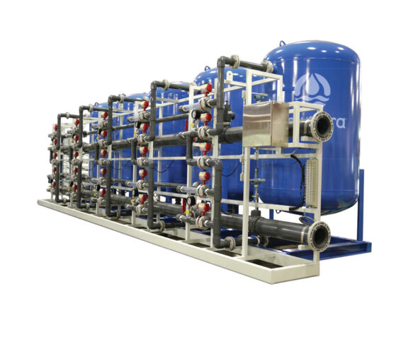 A white and blue metal frame supports a cochrane multi media filtration system consisting of five elevated blue vessels and a series of pipes in various sized containing gauges and other omponents supporting the water filtration process