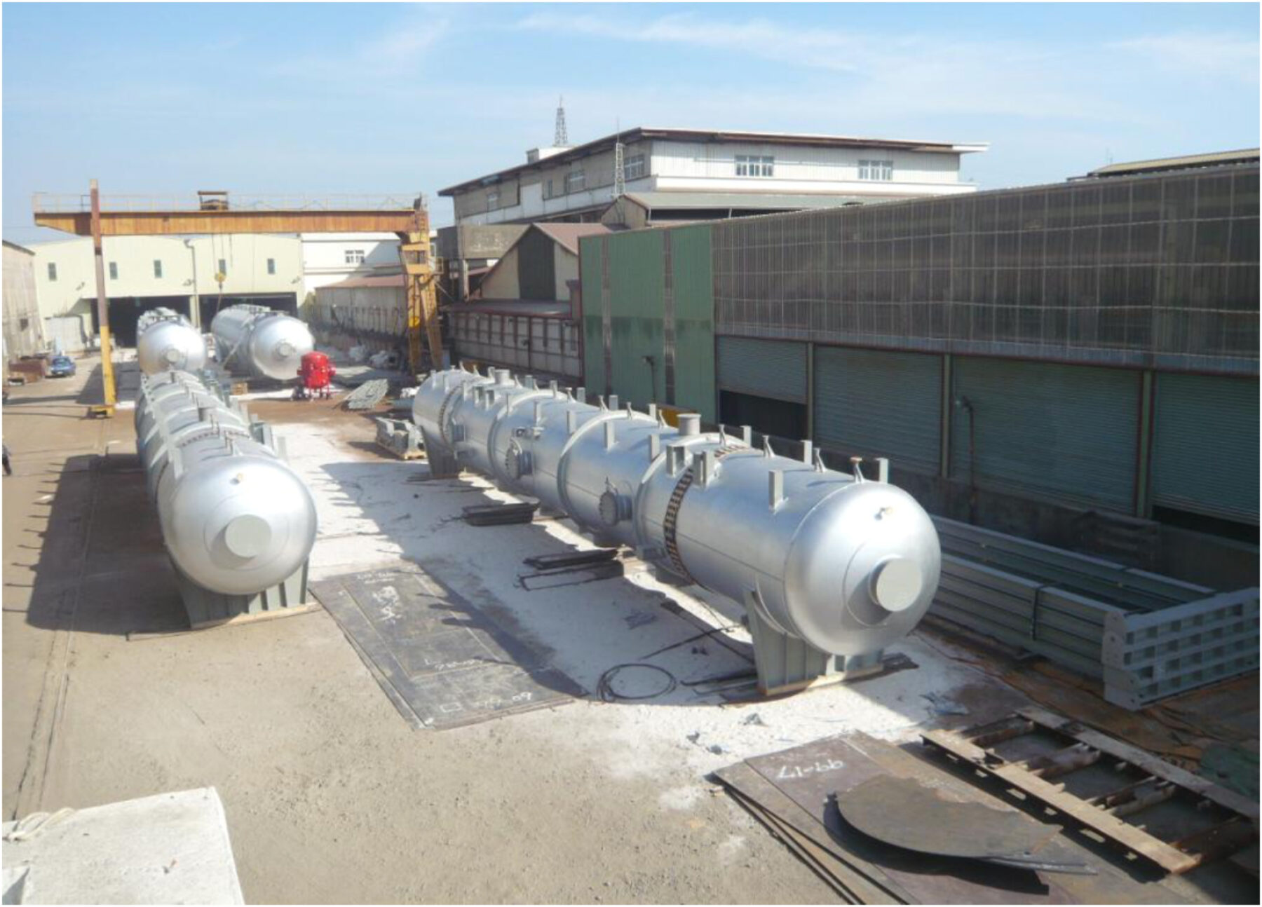 Four Cochrane counterflow deaerator units sit outside an industrial or manufacturing warehouse consisting of horizontally positioned metal vessels with numerous support points