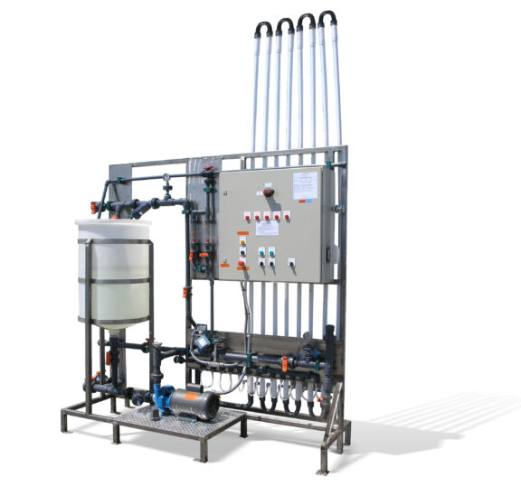 Newterra ultrafiltration system consisting of a tank, pipes, hoses, and tubing to a control panel with switches on an elevated stand.