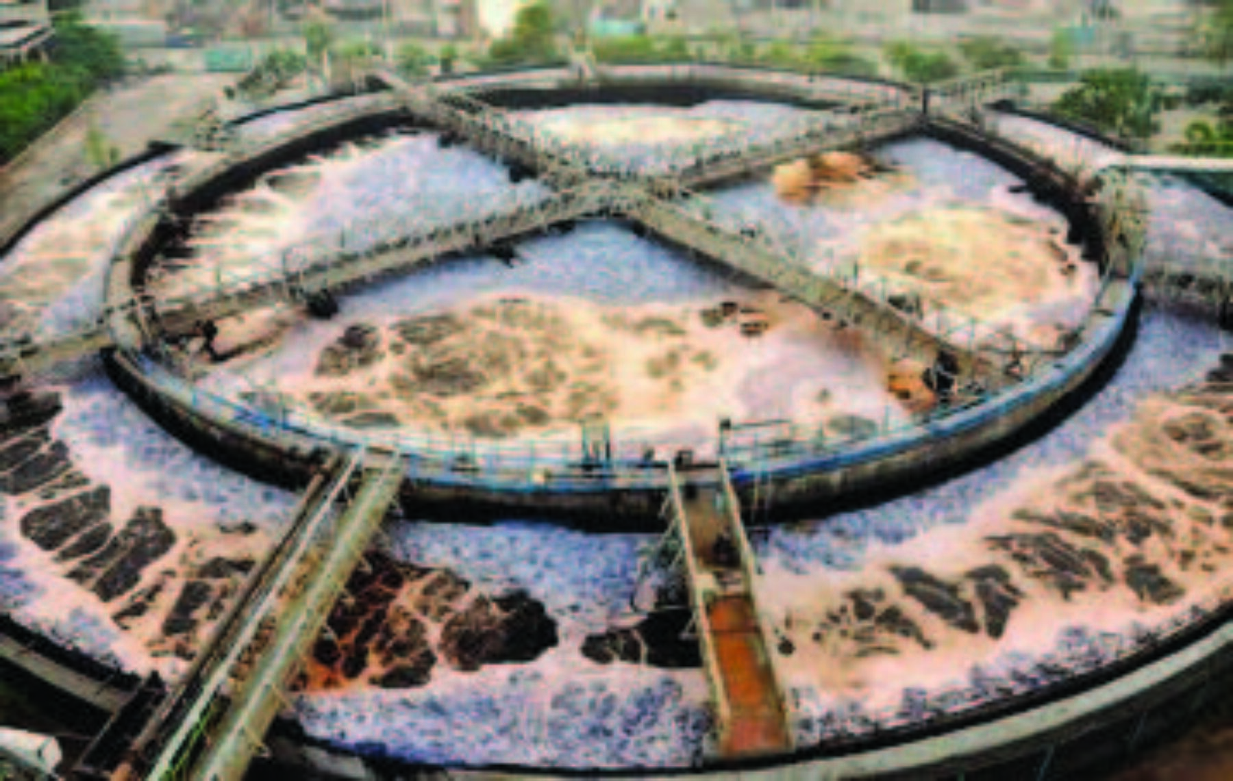 An aerial view of a green treatment process consisting of a large volume of water contained in two rings with aeration technologies agitating the water with platforms forming an x across the top of the center pool of water