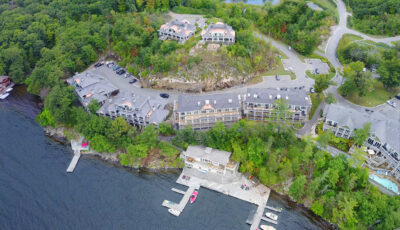 Aerial view of a waterfront residential development area with seven multiunit condominiums