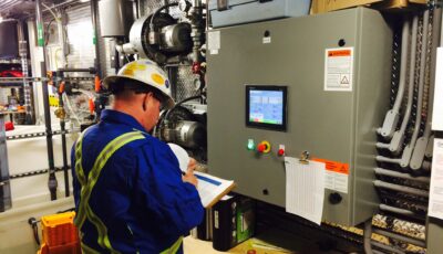 Newterra technician uses a clipboard to write notes while in industrial water treatment plant