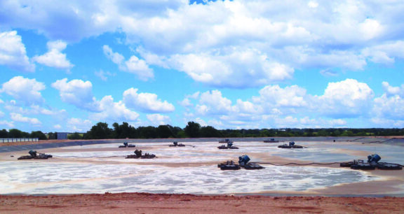 Surface level water agitators aerate a holding pond
