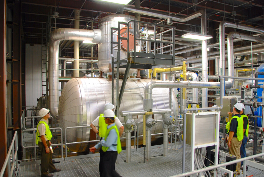 Water treatment professionals gather around a water treatment tank