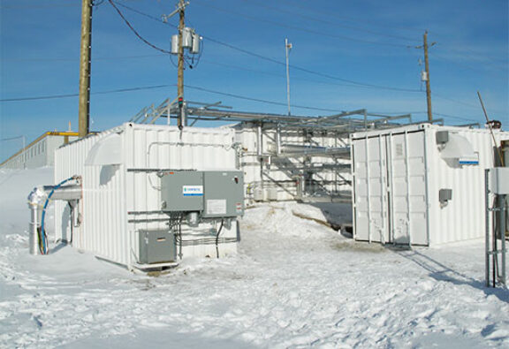 Newterra potable water treatment plant near electrical lines with two modular shipping container systems in a mining environment in winter