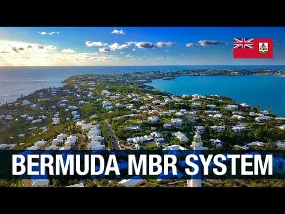 Drone view of Bermuda's populated coastline illustrating infrastructure with Bermuda flag in upper left and 