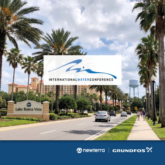 Palm trees along a roadway with a large white conference banner in the center, Lake Buena Vista signage visible nearby.
